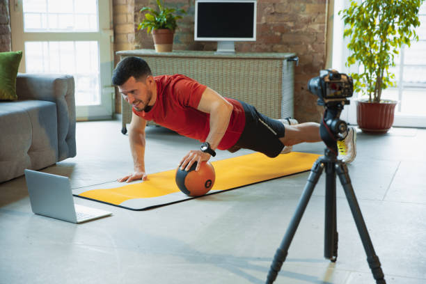 istock Young caucasian man training at home during quarantine of coronavirus outbreak, doing exercises of fitness, aerobic. Staying sportive during insulation. 1249790549