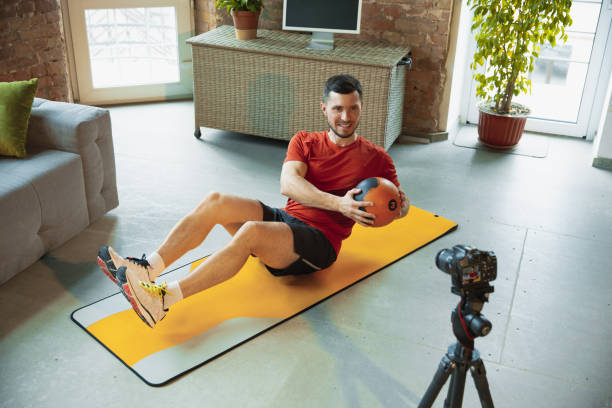 istock Young caucasian man training at home during quarantine of coronavirus outbreak, doing exercises of fitness, aerobic. Staying sportive during insulation. 1249790554