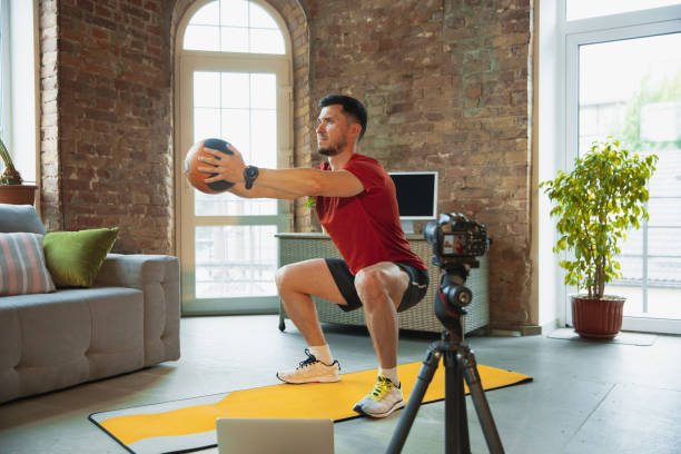 istock Young caucasian man training at home during quarantine of coronavirus outbreak, doing exercises of fitness, aerobic. Staying sportive during insulation. 1249790559