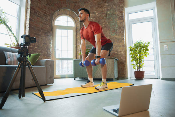 istock Young caucasian man training at home during quarantine of coronavirus outbreak, doing exercises of fitness, aerobic. Staying sportive during insulation. 1249790575