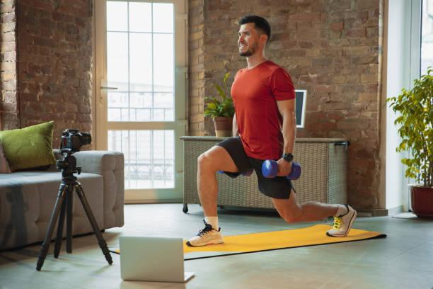 istock Young caucasian man training at home during quarantine of coronavirus outbreak, doing exercises of fitness, aerobic. Staying sportive during insulation. 1249790586