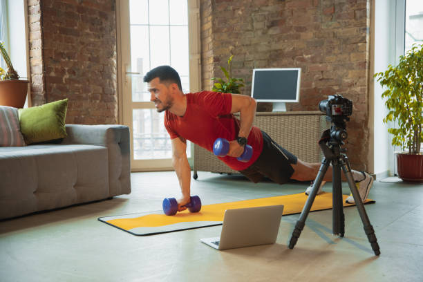 istock Young caucasian man training at home during quarantine of coronavirus outbreak, doing exercises of fitness, aerobic. Staying sportive during insulation. 1249790592
