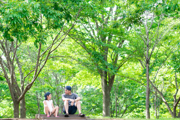 Father and daughter sitting and talking in the woods