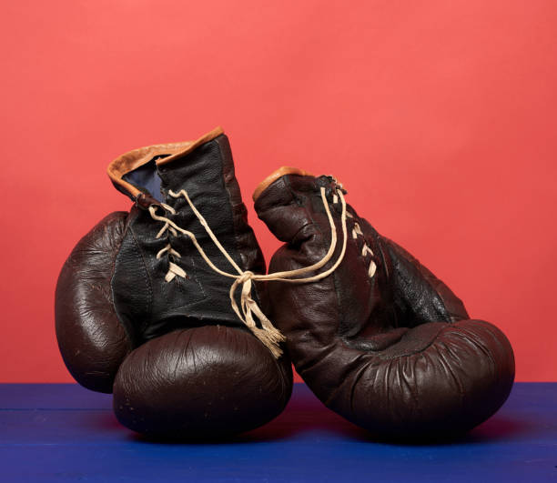 istock brown leather vintage boxing gloves on a red background 1249792628