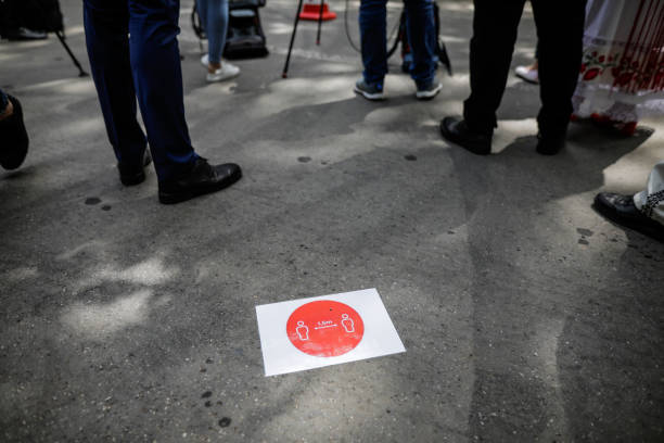 istock Covid-19 social distancing sign on the pavement. 1249795562