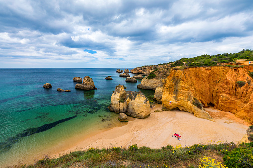 View of stunning beach with golden color rocks in Alvor town , Algarve, Portugal. View of cliff rocks on Alvor beach, Algarve region, Portugal.