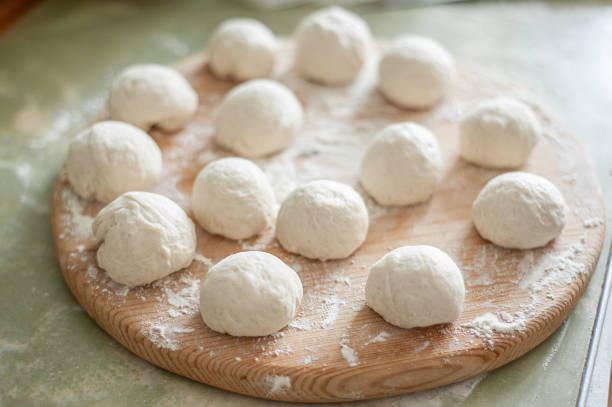 istock Balls from the dough on a wooden board 1249798865