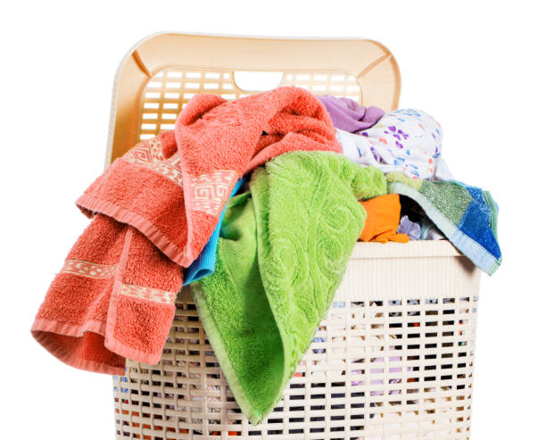 istock Laundry basket full of dirty washing (isolated on white) 1249798942