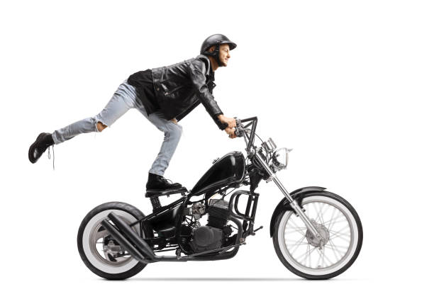 istock Daredevil biker standing on the seat and riding a chopper motorbike 1249799264