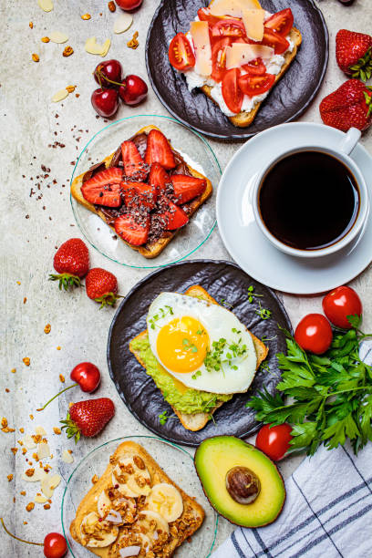 istock Breakfast different toasts with berries, cheese, egg and fruit, gray background, top view. Breakfast table concept. 1249801391
