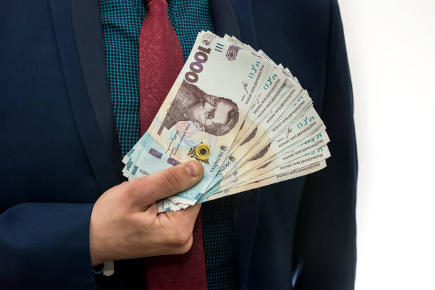 man in a suit with a huge pile of Ukrainian money. 1000 hryvnia. UAH. A man in a suit with a huge pile of Ukrainian money. 1000 hryvnia. UAH. ukrainian currency stock pictures, royalty-free photos & images
