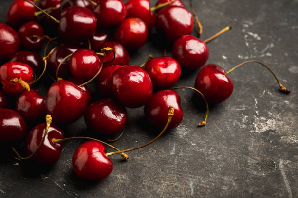istock Ripe and juicy cherries on the dark rustic background 1249805950