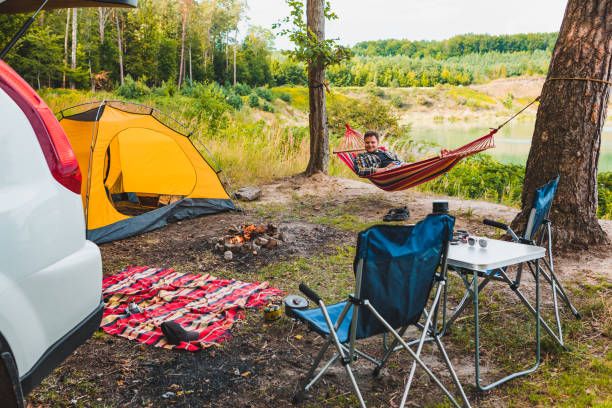 istock man laying on hammock at lake beach near camp fire 1249806353