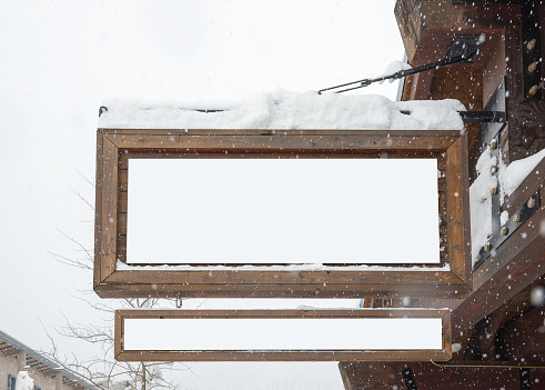 wooden billboard with snow covered with the snow for product display montage..