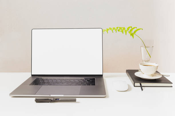 istock Mockup of laptop with mouse and pen with coffee cup over notebook on white table. 1249808473