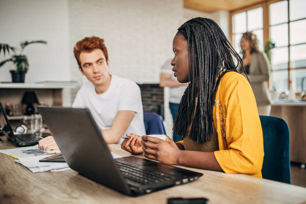 istock Two young business people working together in office 1249808499