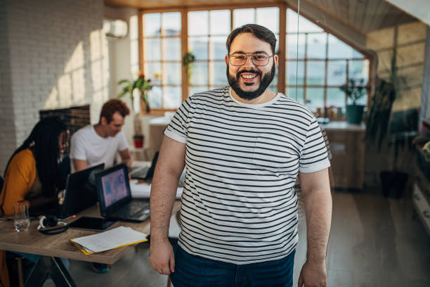 verticale d’un homme dans le petit bureau moderne - heavy work photos et images de collection