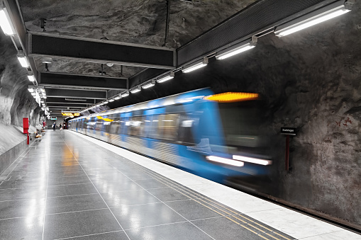 Puteaux, France - April 9, 2023: Passengers get ready to board the train arriving at the platform in La Defense - Grande Arche underground station on Line A of the RER public transportation network.