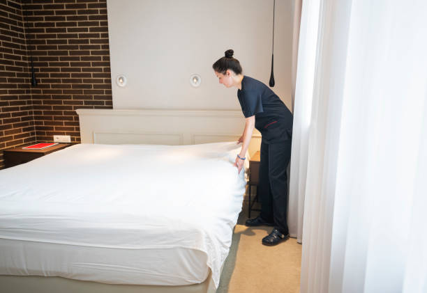 istock Maid doing the bed, preparing hotel room for guests 1249812959