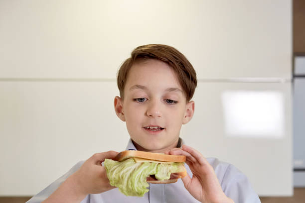 istock Close-up face of a handsome brunet boy who eats a sandwich. 1249813503