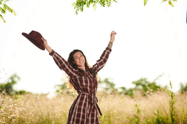 portrait of a brunette girl wearing a plaid dress and a red hat