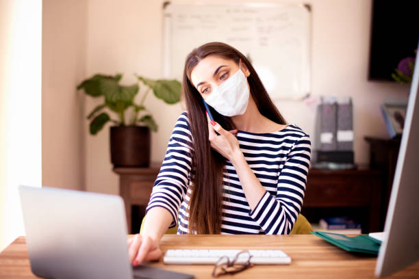 istock Young woman talking with somebody on her mobile phone while working from home 1249815955