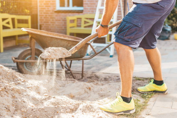 Cropped image of man digging sand with a shovel - DIY do it yourself and home works concept stock photo