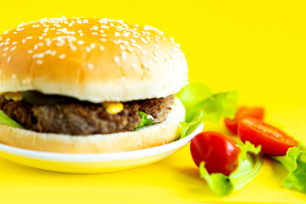 istock Fresh tasty cheeseburger on bright yellow background, closeup 1249819028