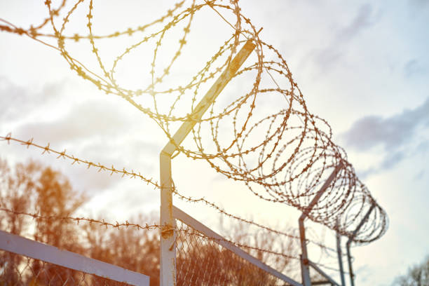 istock Barbed wire on fence restrict access to the restricted area. 1249820823