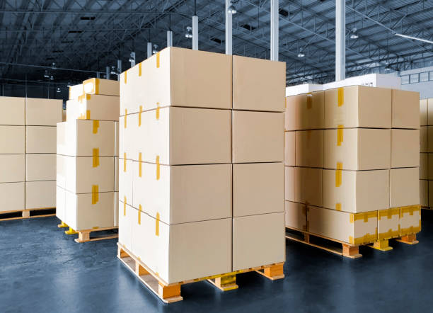 istock Stack of shipments boxes on wooden pallets at interior of warehouse storage. 1249823863
