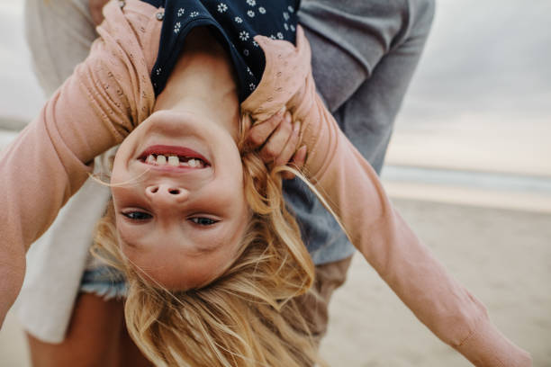 istock Girl playing with her parents at the beach 1249826544