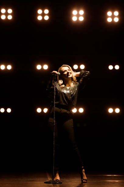 istock Vocalist singing to microphone. Singer in silhouette 1249826592