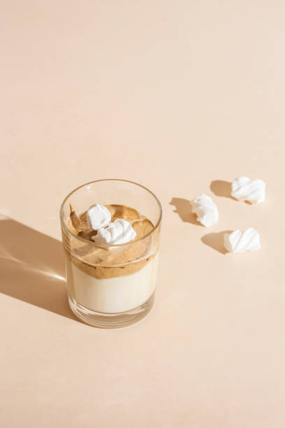 マシュマロとパステルの背景にミルクと透明なガラスでダルゴンコーヒー。垂直方向 - milk shake coffee latté cold ストックフォトと画像
