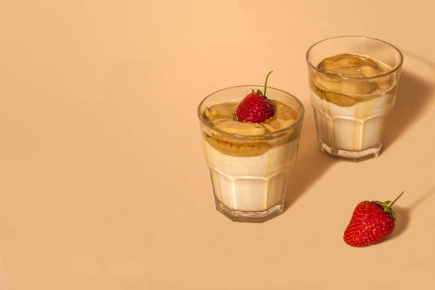 istock Dalgon coffee in a transparent glass with milk on a pastel background with strawberries. Copy space 1249826675