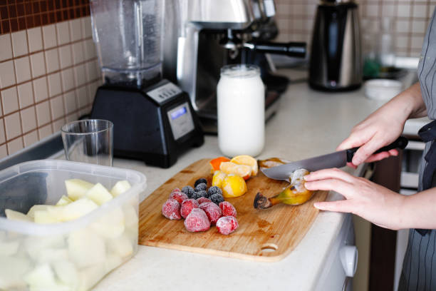 istock Young woman preparing strawberry milkshake 1249834673