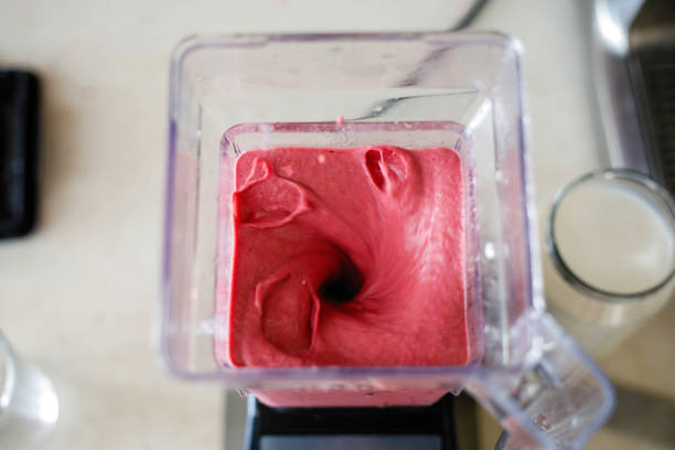 istock Young woman preparing strawberry milkshake 1249835120