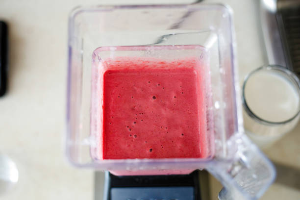 istock Young woman preparing strawberry milkshake 1249835122
