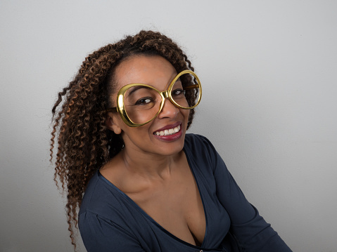 Horizontal portrait of a joyful Afro American woman wearing funny eyeglasses