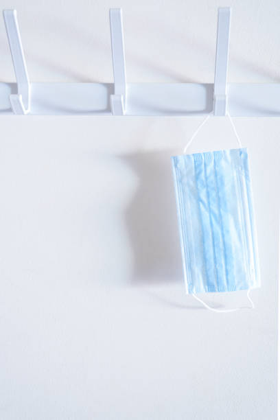 istock Surgical mask hanging on a coat rack. Concept of new normal 1249837641