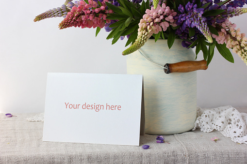 mockup, scene creator with a cardboard card and a bouquet of lupins. space for your design.