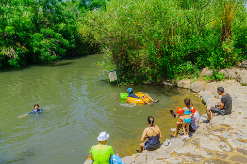 Golan, Israel - June 10, 2020: View of the Daliyot stream, with visitors bathing, in the Majrase - Betiha (Bethsaida Valley) Nature Reserve, Northern Israel