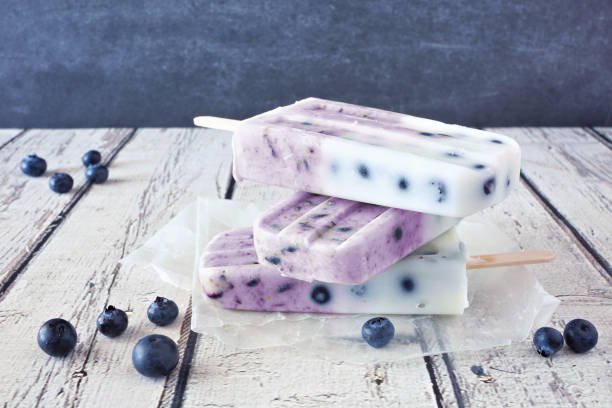 istock Blueberry yogurt popsicles stacked against a rustic white wood background 1249842543