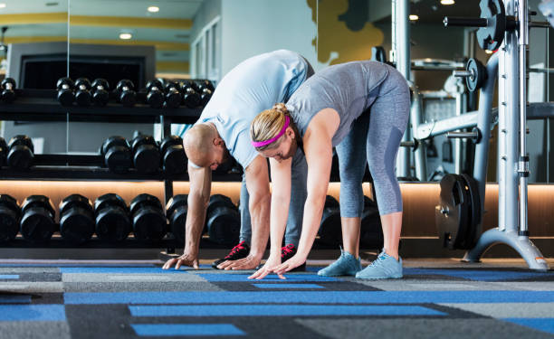 istock Hispanic couple working out at the gym, stretching 1249843375