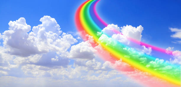 White clouds in the blue sky and colourful rainbow