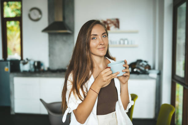 istock Woman sitting in the kitchen and drinking coffee 1249849720