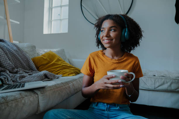 istock Young female taking a break from work, while studying at home on the sofa with a cup of coffee 1249851216