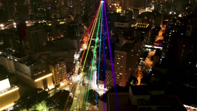Aerial view of city life scene with led rainbow projected at night. Great landscape.