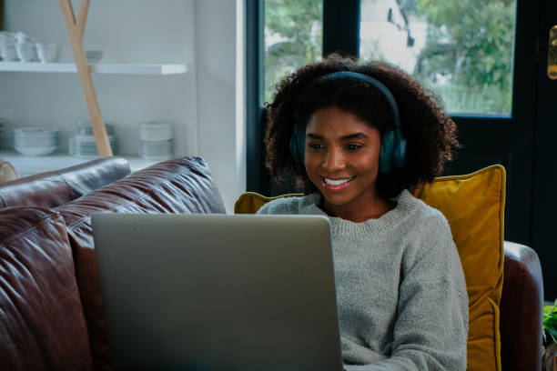 istock Happy and beautiful female on the sofa working on her laptop or computer 1249852290