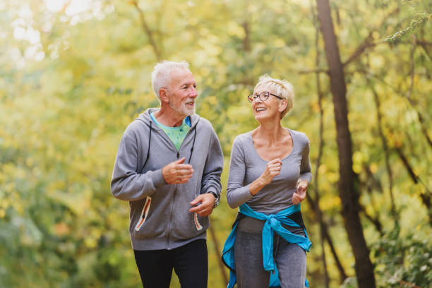 istock Smiling senior couple jogging in the park 1249852469
