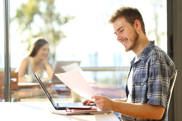 l’étudiant heureux travaille sur l’ordinateur portatif dans un café - scholarship holder photos et images de collection